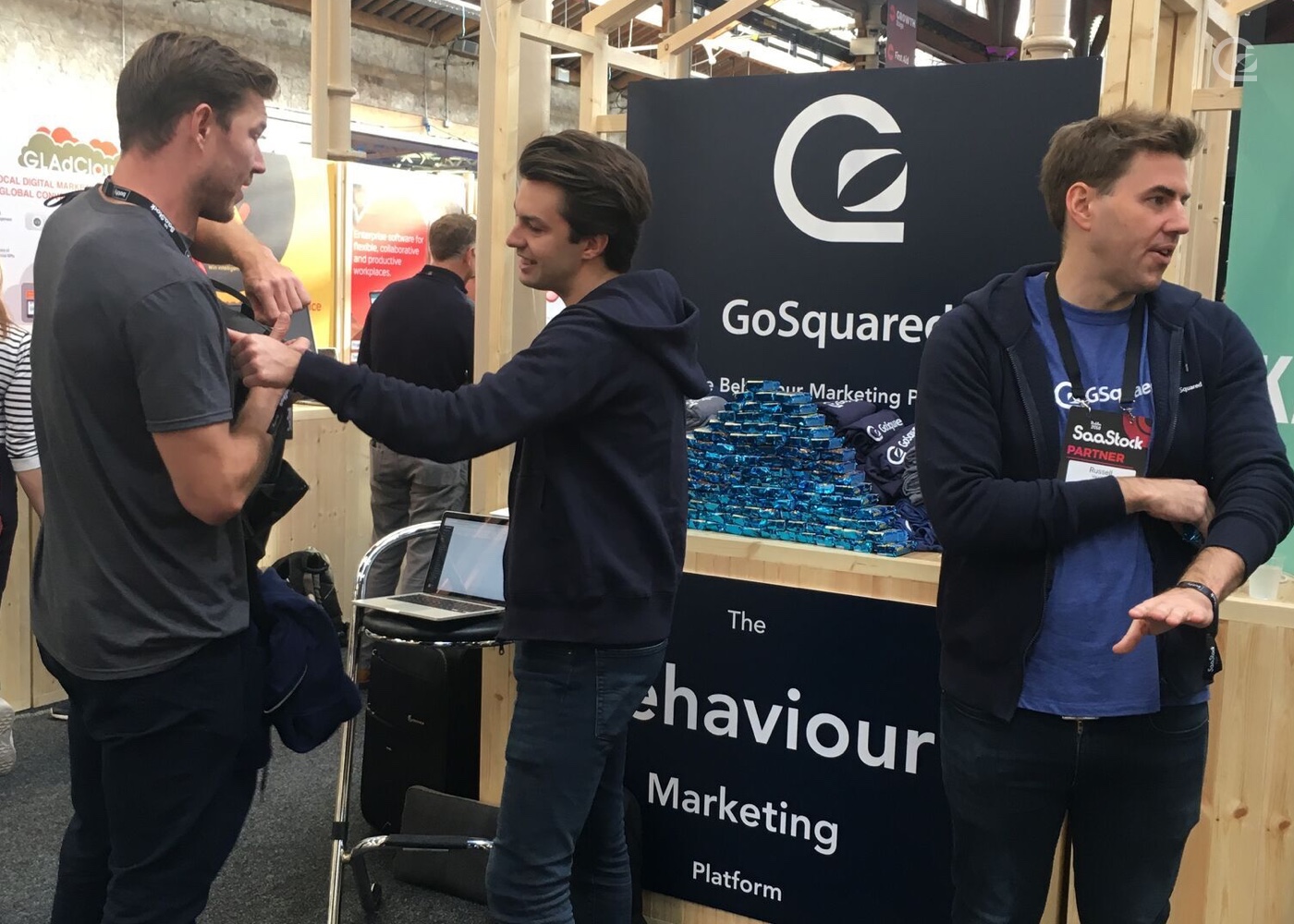 James and Russell at the GoSquared stand with rice Krispy squares talking to another vendor